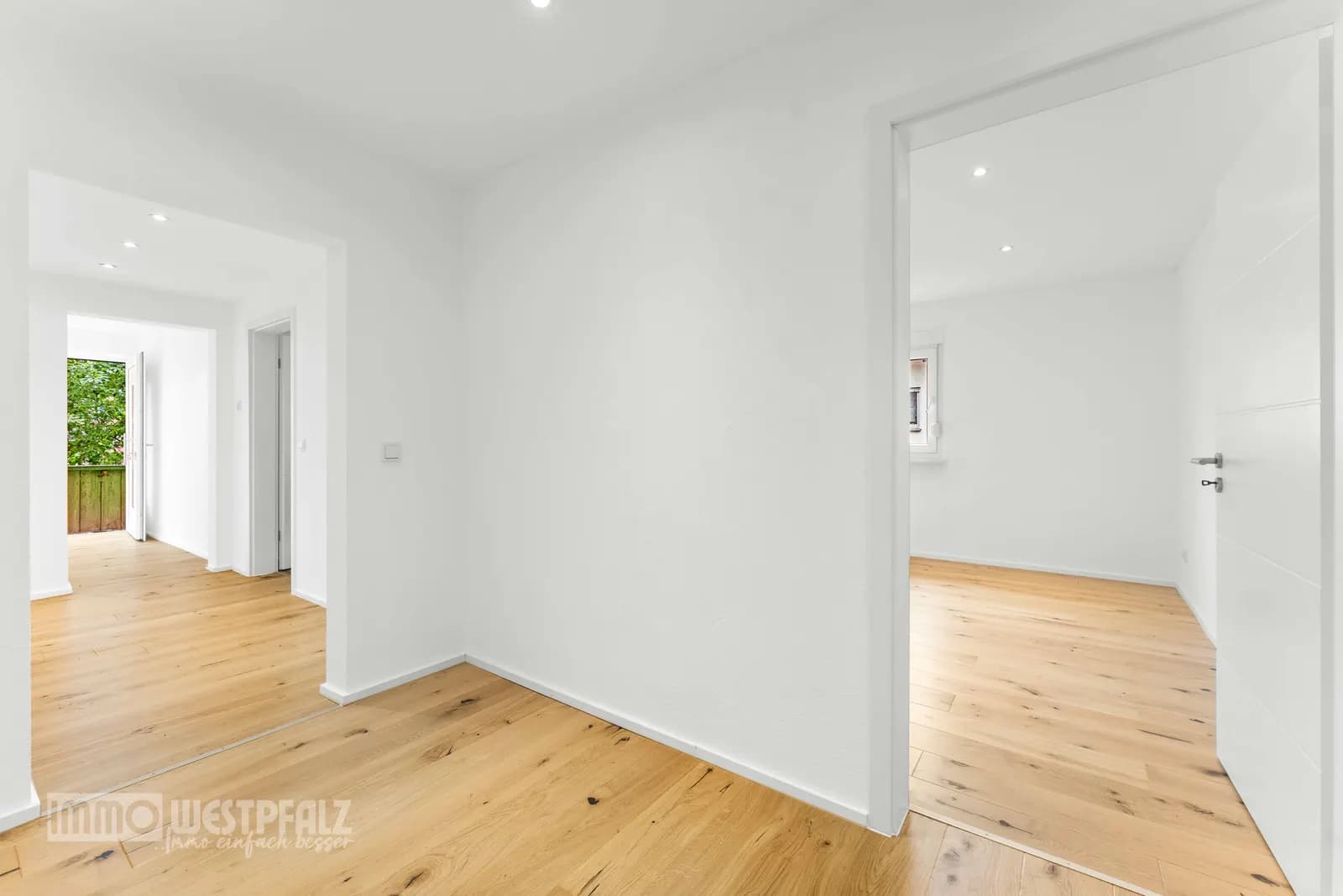 Helle Innenräume mit Parkettboden und weißen Wänden — authentische Weitwinkelperspektive für die Immobilienvermarktung.