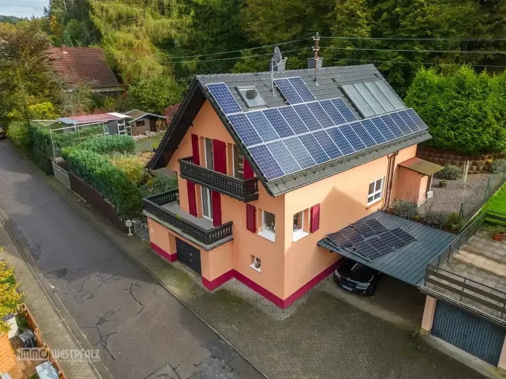 Professionelle Immobilienaufnahme aus der Luft mit Pool, Terrasse und Außenanlagen.