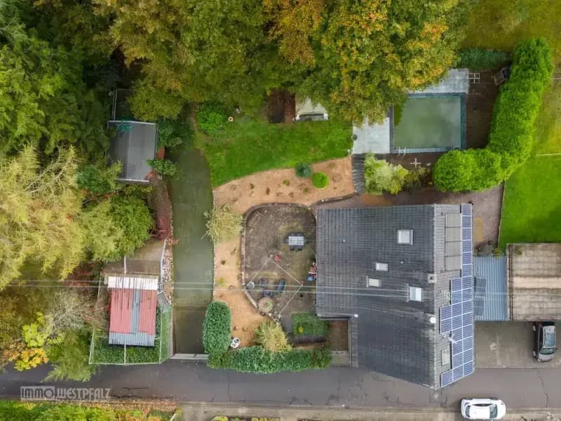 Luftaufnahme eines großen Grundstücks mit Wohnhaus und Gartenflächen.
